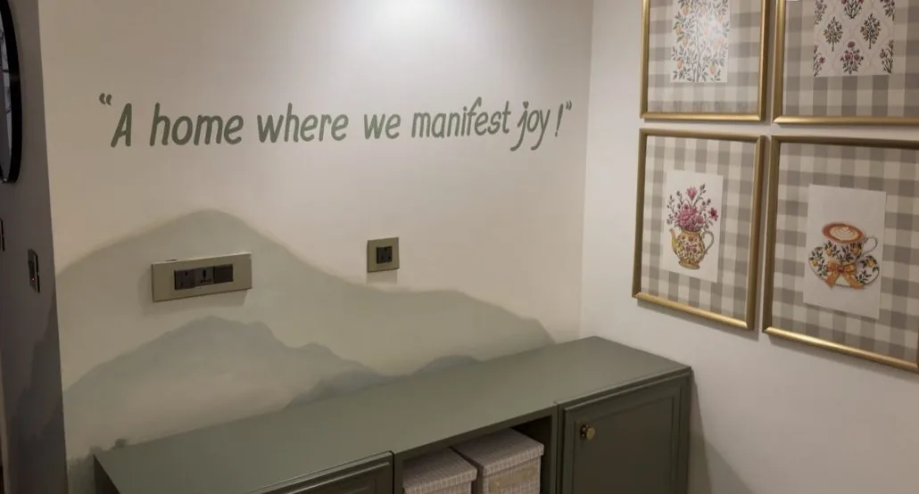 Before: sage green console under the ‘A home where we manifest joy’ wall quote, with gingham-framed prints and nothing on top