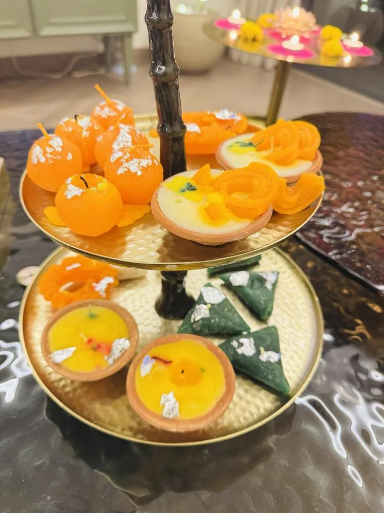 Two-tier palm stand of mithai-shaped candles: laddoo, jalebi and barfi