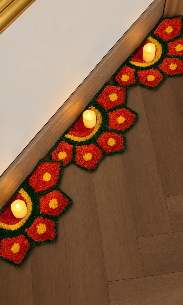 Marigold floral rangoli border along the floor with LED candles