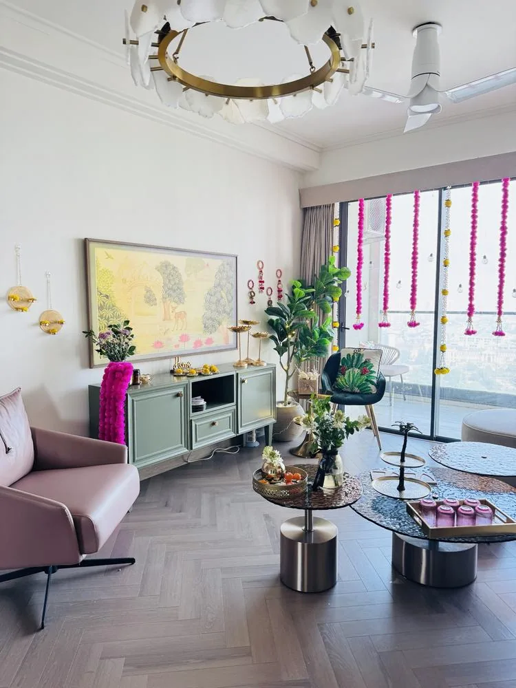 Wide daytime view of the living room with chandelier and pink marigold hangings