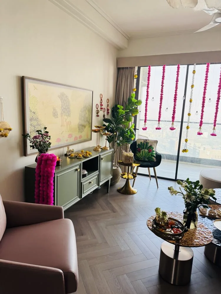 Living room by day with sage console, wall diyas and pink hangings at the balcony