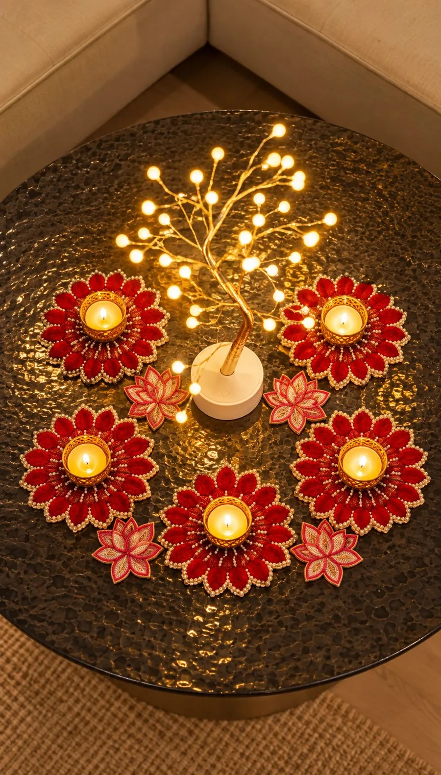 Coffee table seen from above with a red flower diya rangoli around a glowing tree light