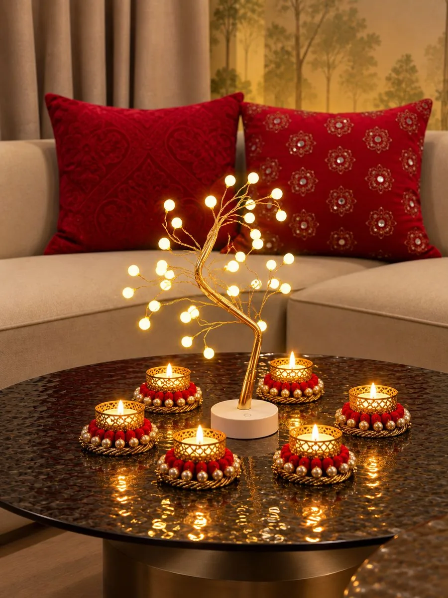 Red tealight holders circling a tree light on a coffee table, with red velvet and mirror-work cushions behind