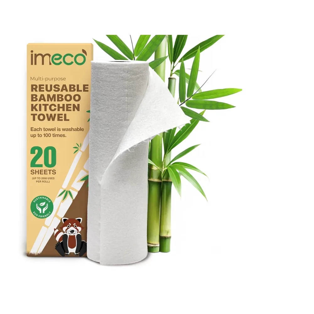 A roll of Imeco reusable bamboo kitchen towels standing beside its box, with bamboo stems behind