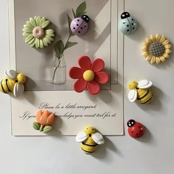 3D bee, ladybug and flower magnets holding a card on a fridge