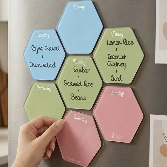 Pastel hexagon acrylic boards on a fridge door, one for each day, with meals written on them