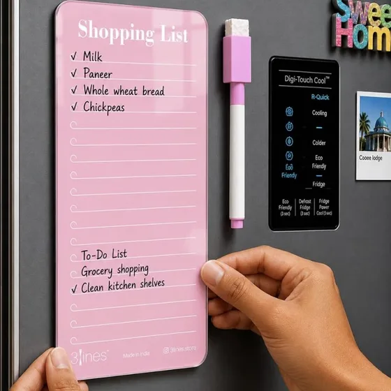 A pink acrylic shopping list board with a marker, being stuck to a fridge