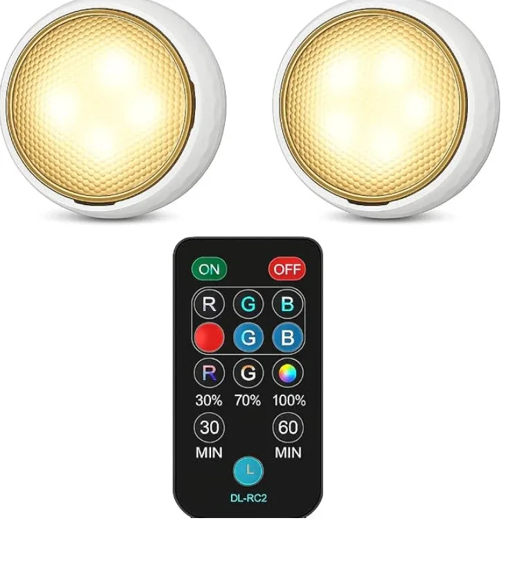 Two round warm-white puck lights with a small remote for dimming and timers