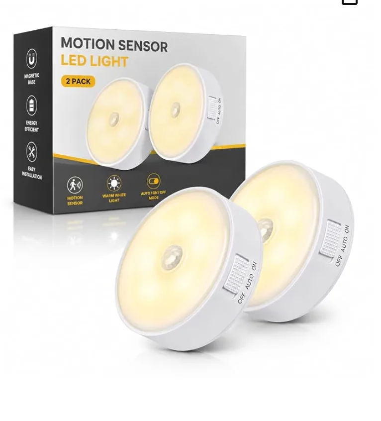 Two round motion-sensor lights with magnetic bases, glowing warm white