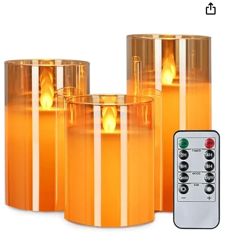 Three flameless glass pillar candles at different heights, flickering, with a timer remote