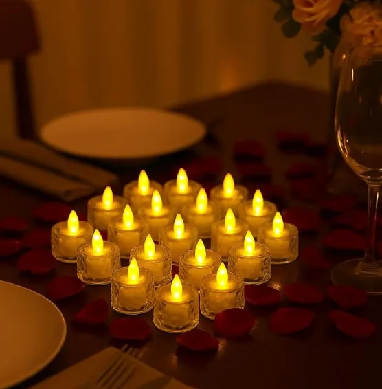A cluster of flickering LED tea lights in textured glass holders on a laid dinner table