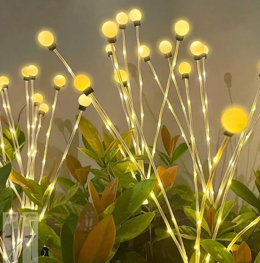 Solar firefly stakes among leaves, with warm globes swaying on thin wires