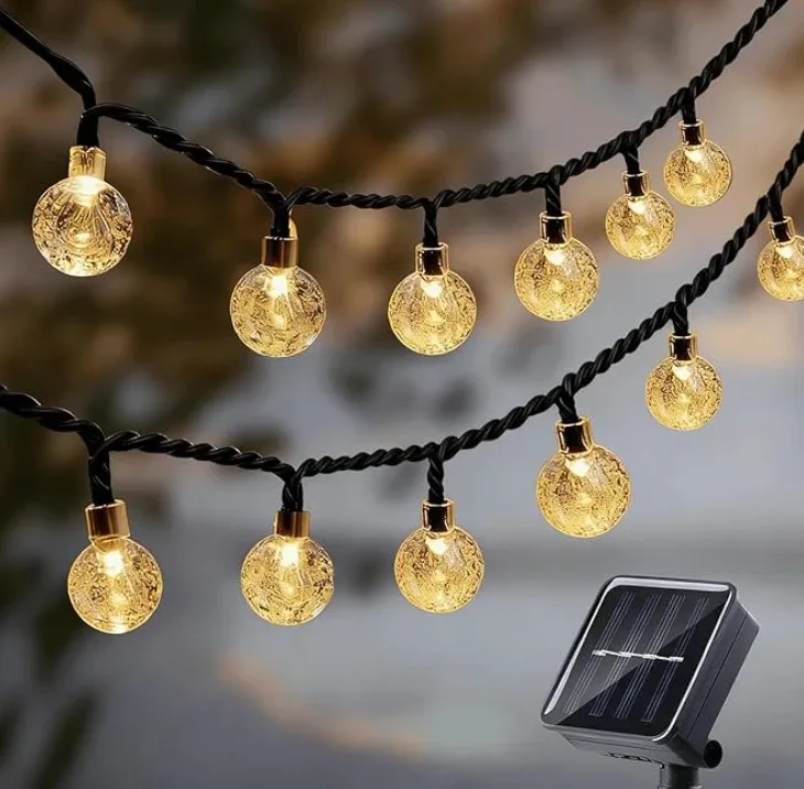 Two strands of crackle-glass globe bulbs on black cord, with the solar panel that runs them