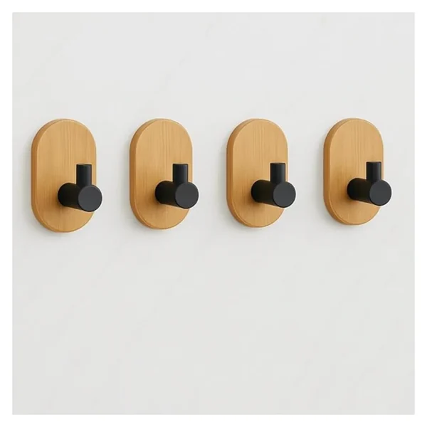 Four oval wooden adhesive hooks with black pegs on a white wall