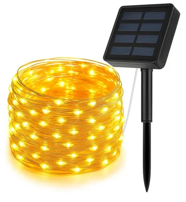 Coil of warm copper-wire fairy lights with a solar panel on a stake
