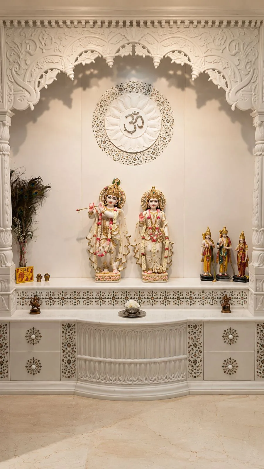 Carved white marble mandir with pillars, a jaali arch and coloured stone inlay across the drawers