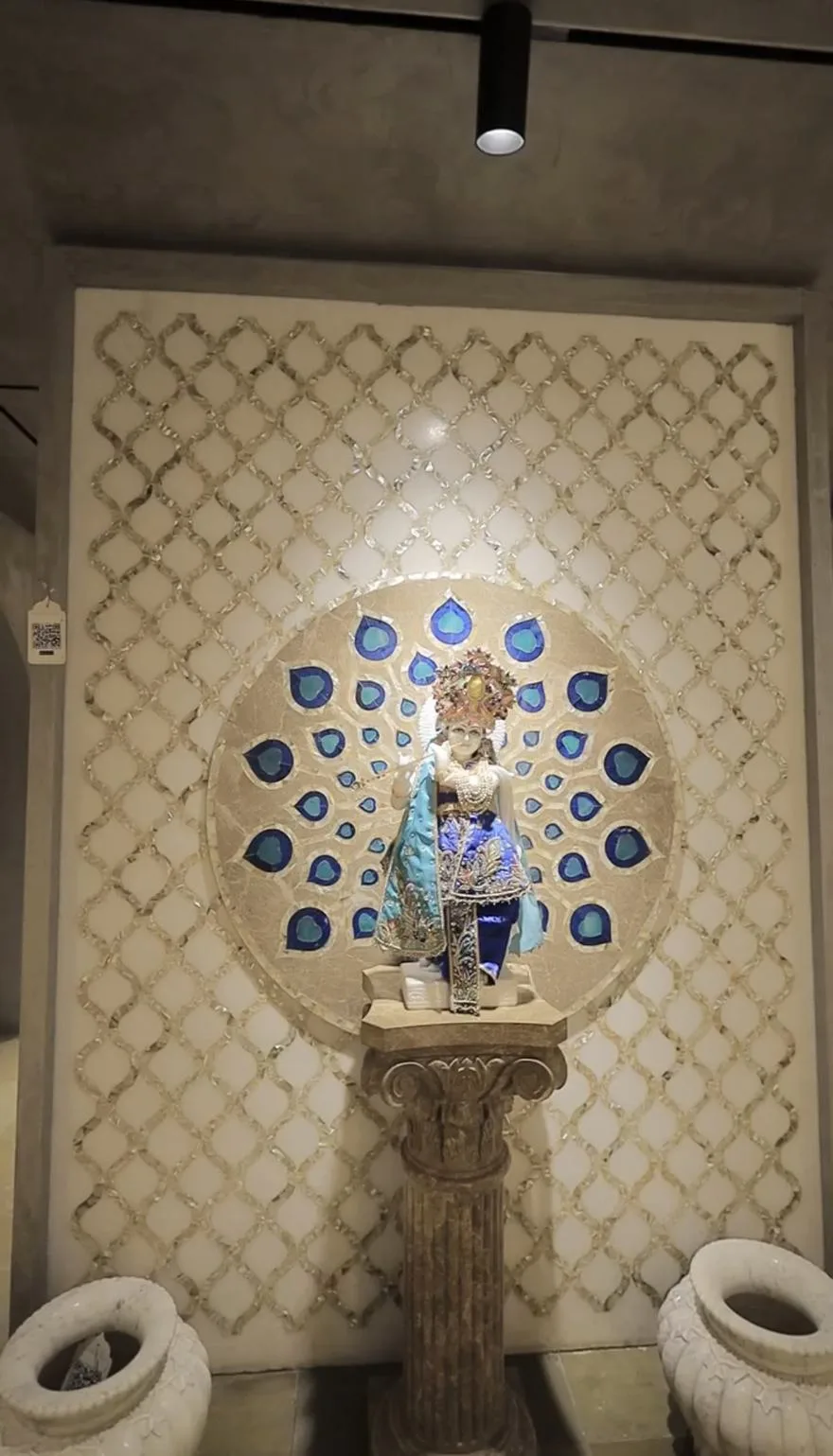 Marble backdrop with a mother-of-pearl lattice overlay and a peacock-feather inlay medallion